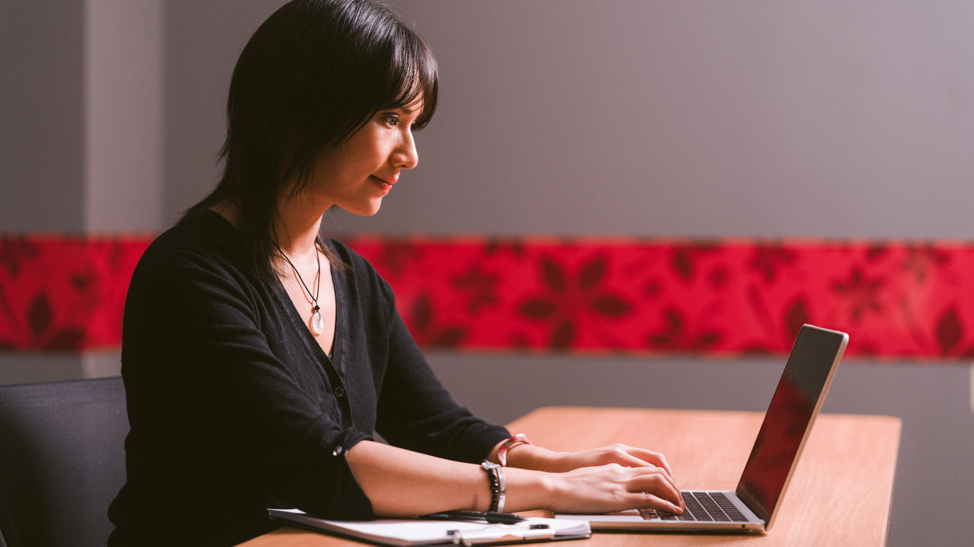 Women using a laptop in a room with Ohio State branding